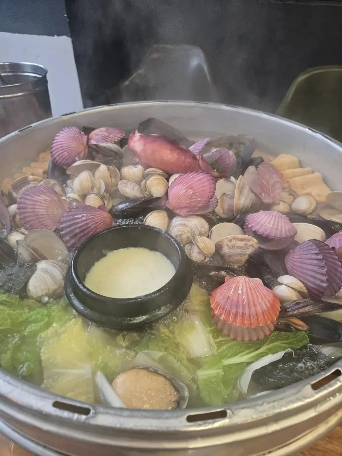 Photo of the hot pot with a variety of clams and seafood