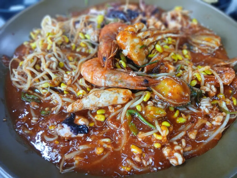 A bite of seafood braise served onto a small plate