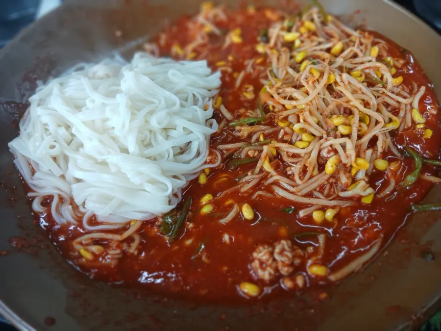 Kalguksu noodles mixed into the seafood braise sauce