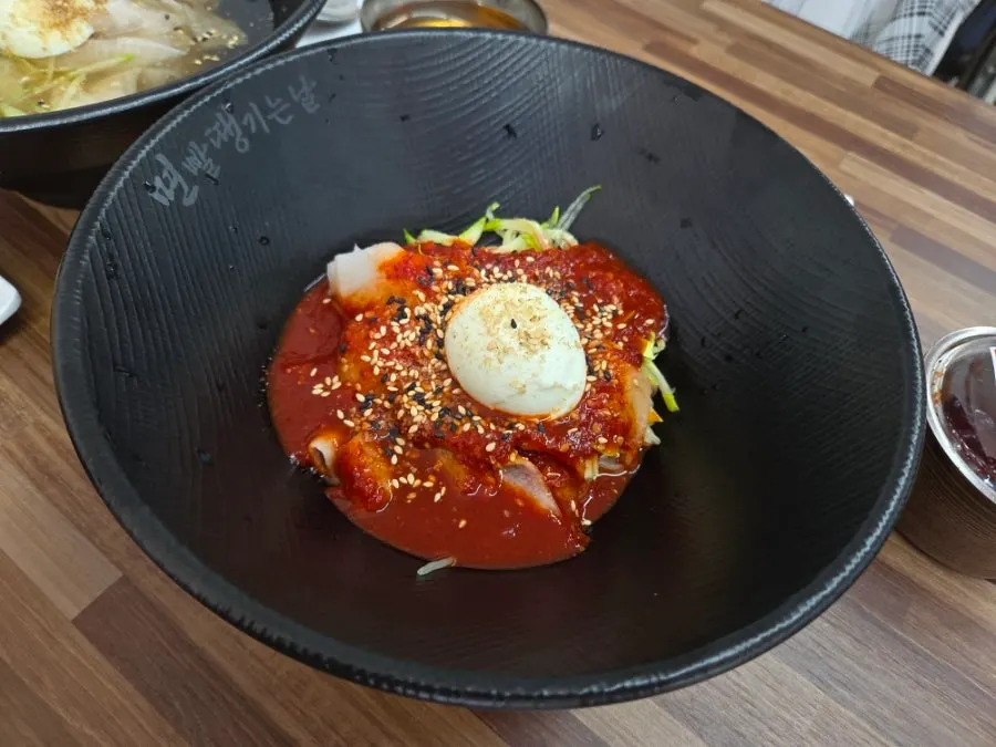 A bowl of bibim milmyeon topped with sauce