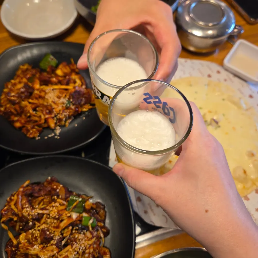 Table spread with pork stir-fry, octopus stir-fry, and wood-fired pizza together