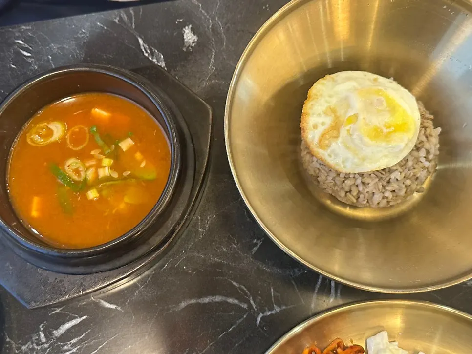 Piring penuh nasi jelai campur dengan lauk sayuran