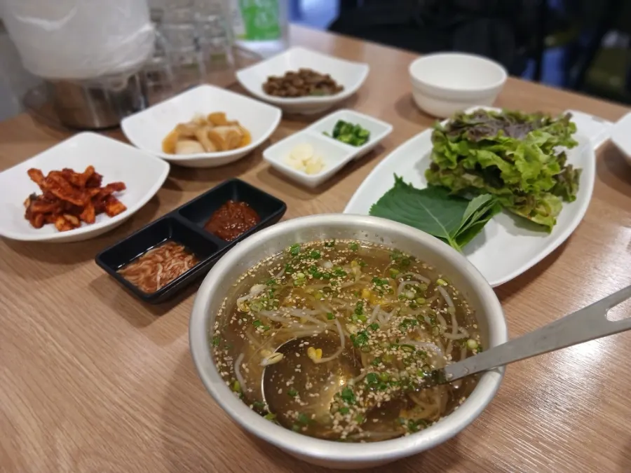 쌈 채소에 족발과 부추무침을 올린 한 쌈