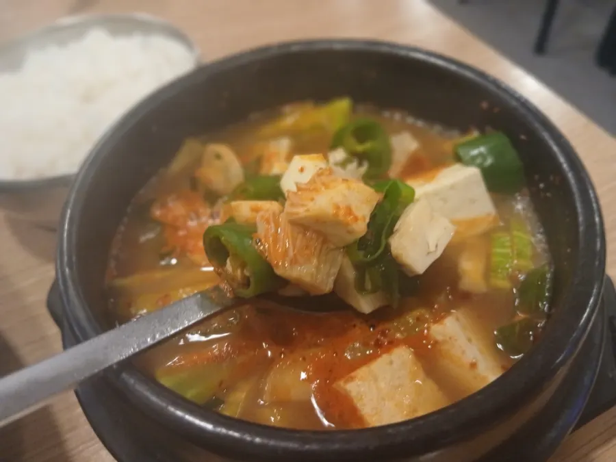 밥 위에 고기와 겉절이를 올린 한 숟갈