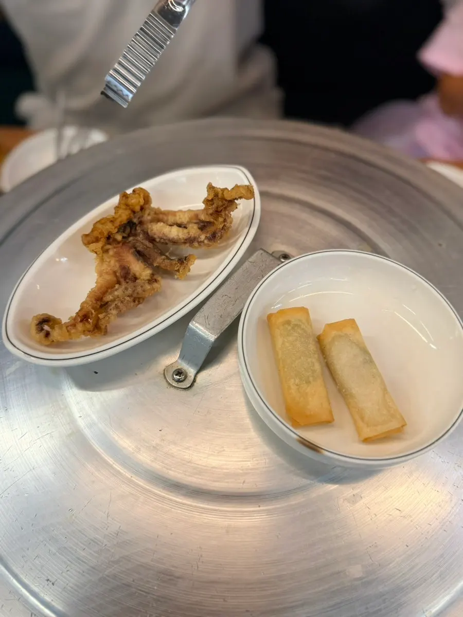 Side dishes including fried squid legs and spring rolls