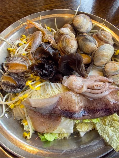 Seafood kalguksu topped with scallops and abalone