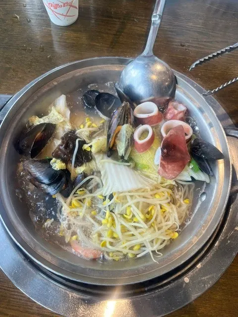 A spoonful of seafood kalguksu broth