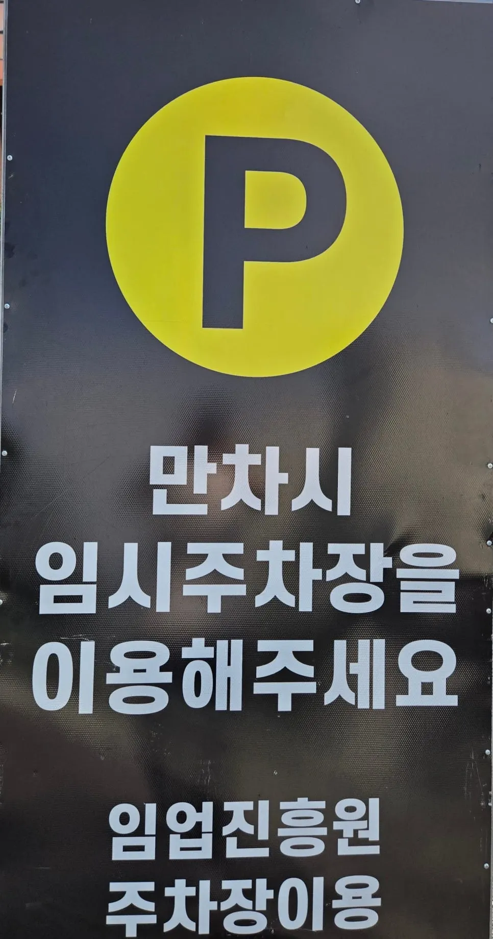 Wide parking lot in front of the restaurant with a temporary parking sign