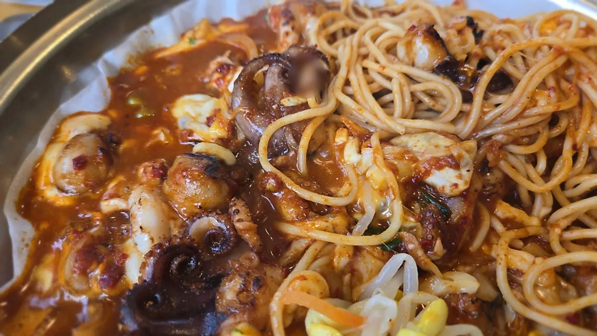 Jjuchipa topped with cheese sauce and pasta