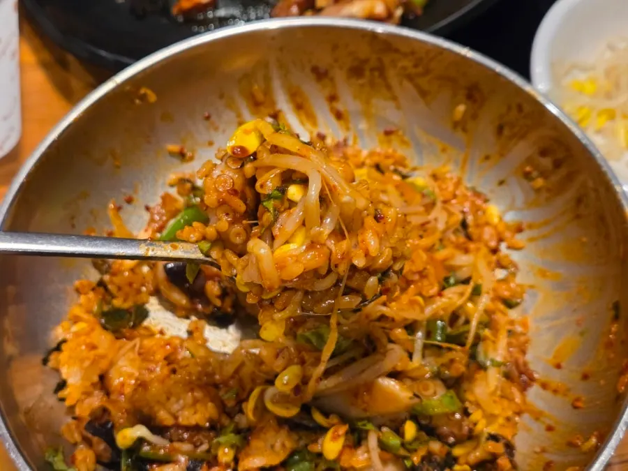 A bite of octopus stir-fry on chopsticks