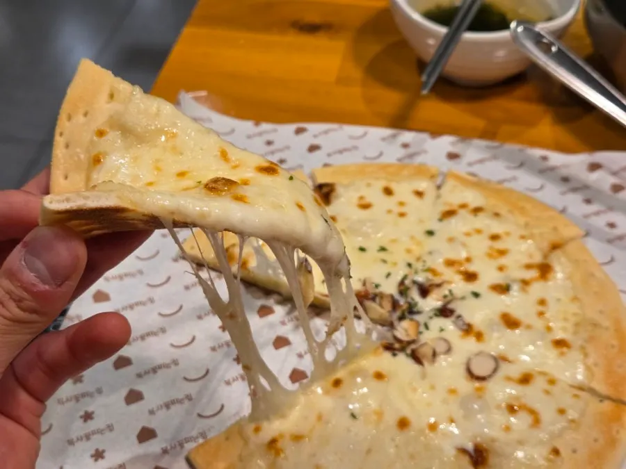 Cheesy slice of gorgonzola pizza stretching