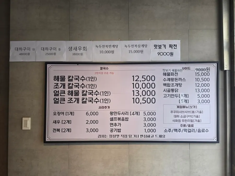 Menu board listing seafood kalguksu and spicy kalguksu