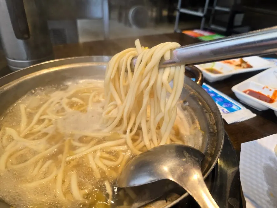 Seafood kalguksu boiling vigorously over high heat