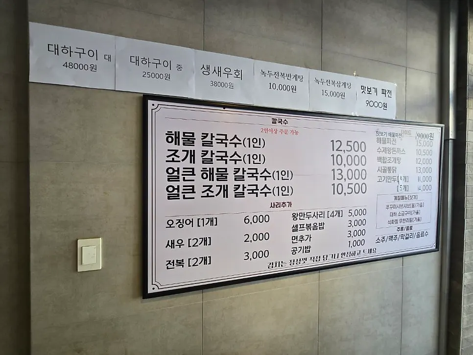 해물칼국수와 대하 구이가 적힌 메뉴판