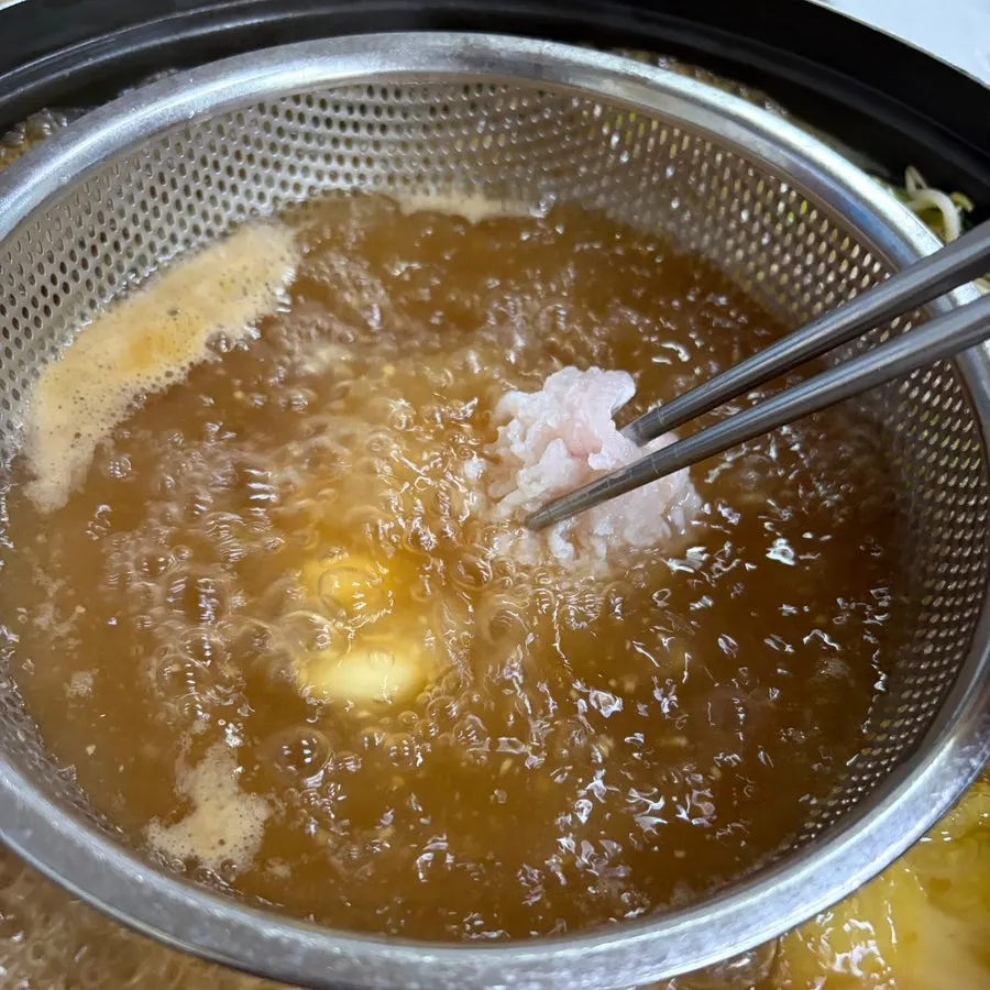 Scored hamo eel being blanched in broth