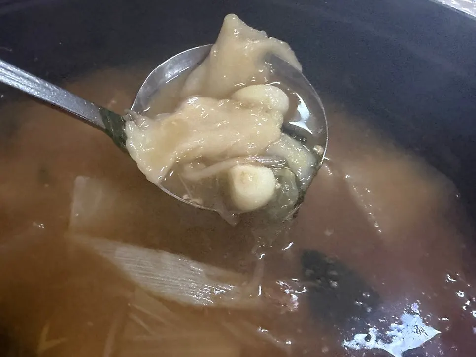 Bowl of chewy dumpling dough soaked in broth