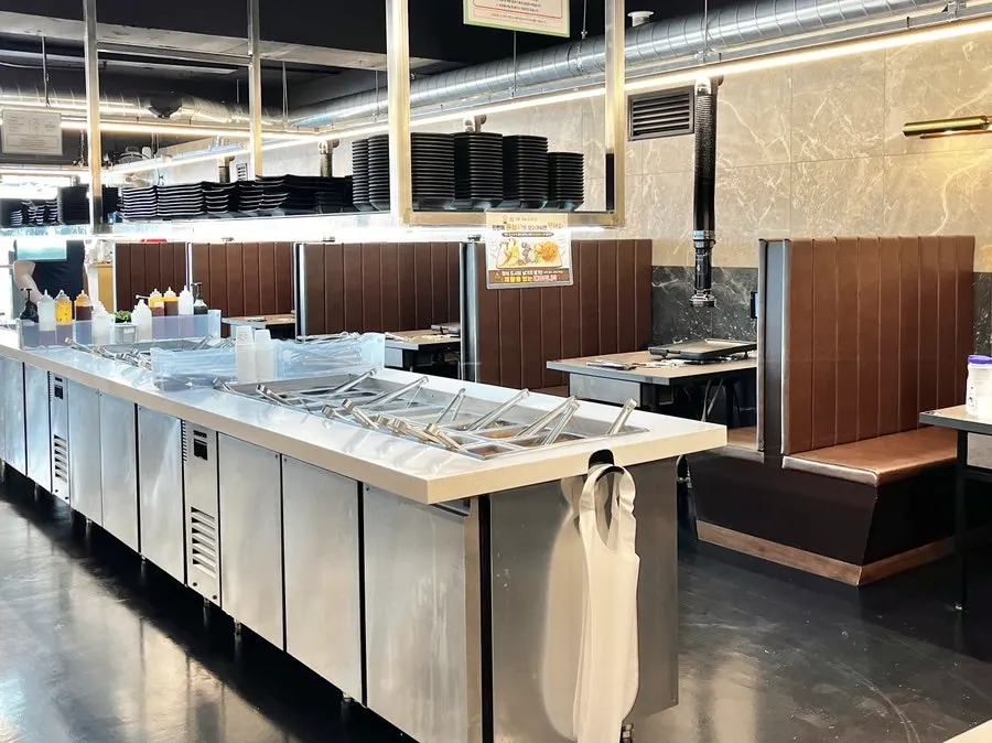 Spacious dining hall with group seating at Daepae Maket Daeyeon