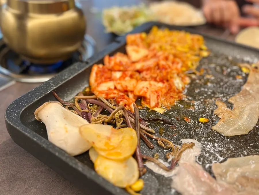 Grill with mushrooms, potatoes, and bean sprouts cooking together