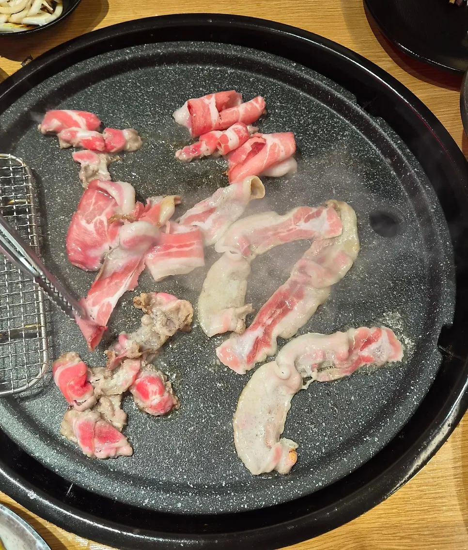 Thin-sliced meat cooking on the grill