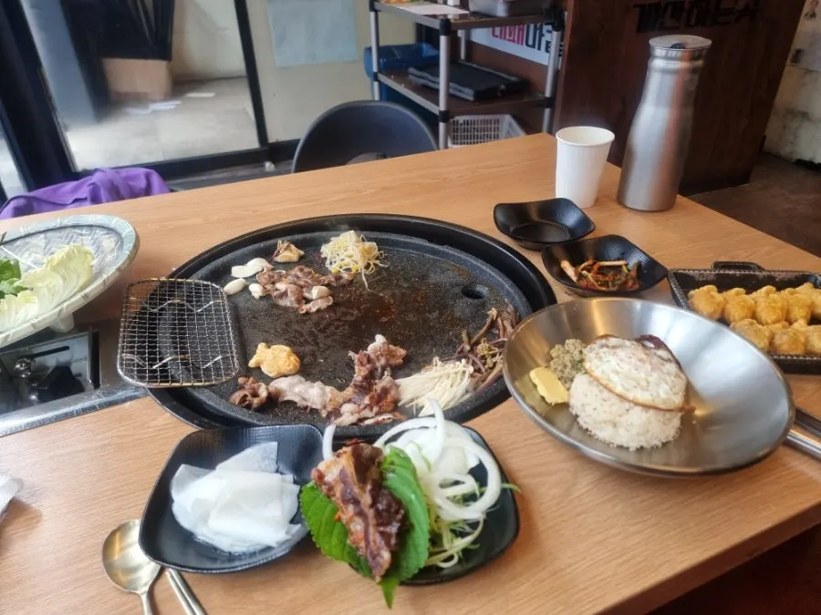 A plate of meat with a variety of sauces