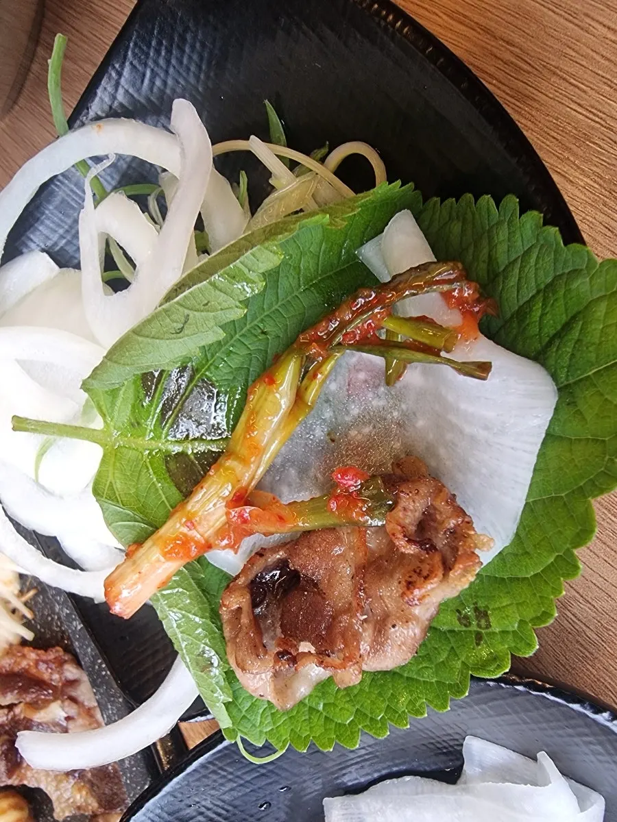 A bite-sized wrap made with pork belly and vegetables
