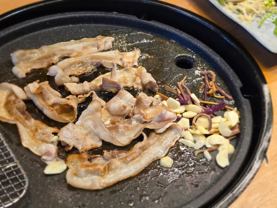 Chewy thin-sliced pork belly plated for the table