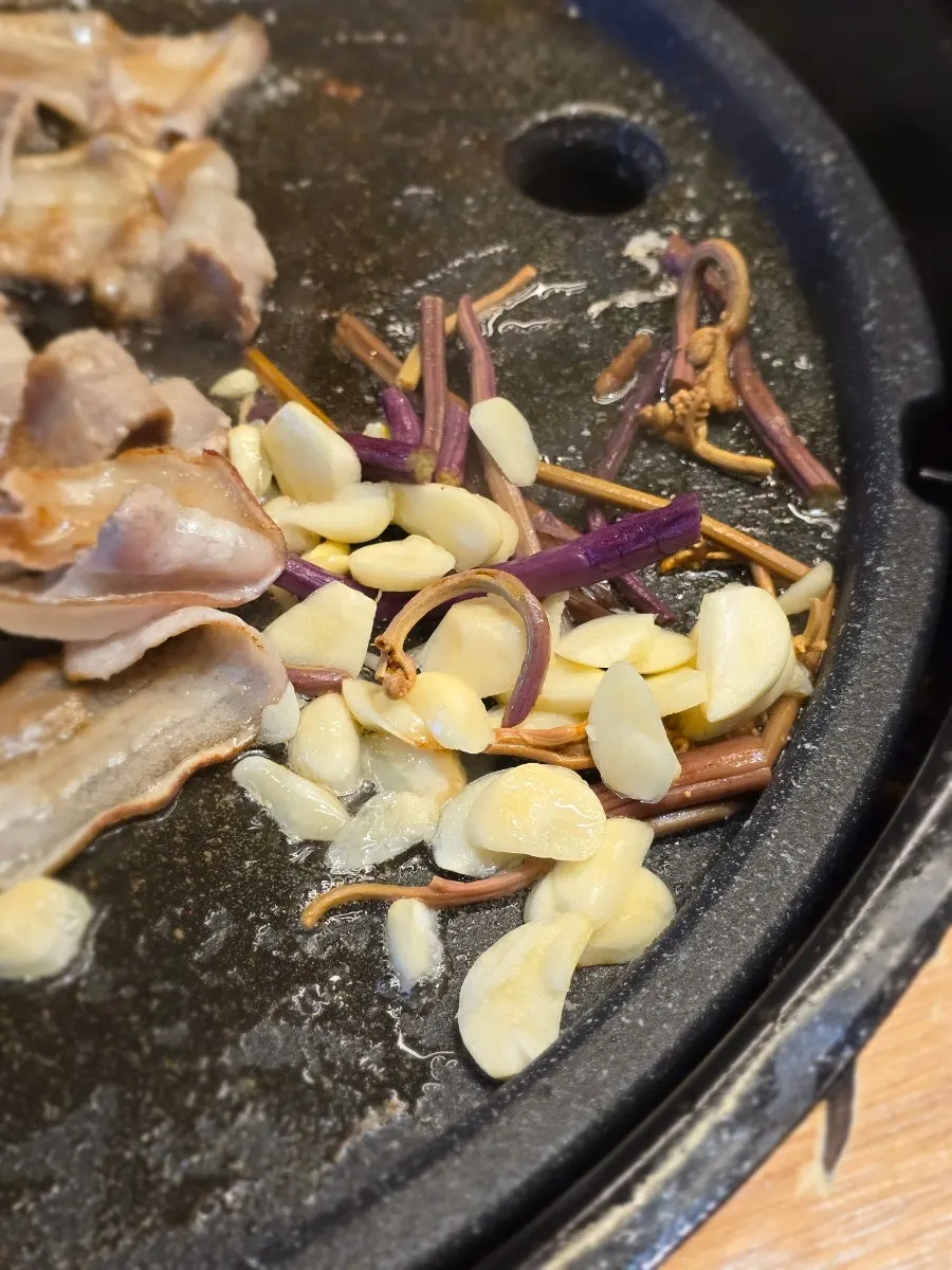 Thin-sliced pork belly cooking quickly on the grill