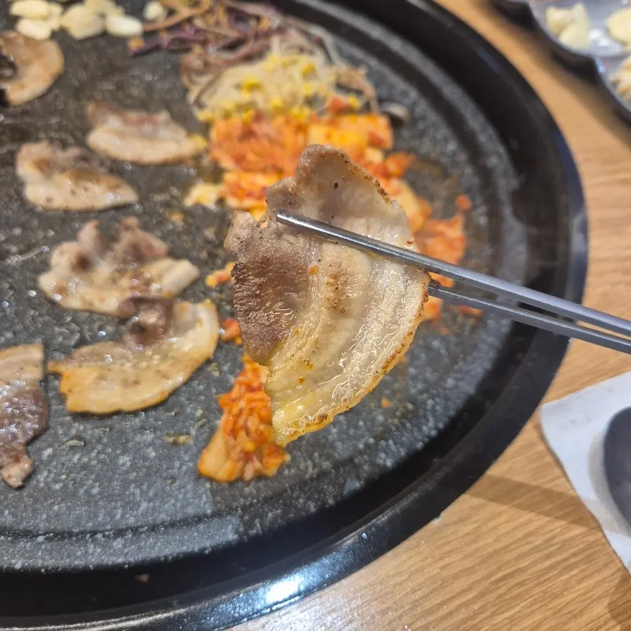 불판에서 야채와 함께 굽는 꽃삼겹살