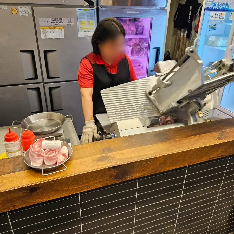 Live cutting station slicing meat with a meat slicer