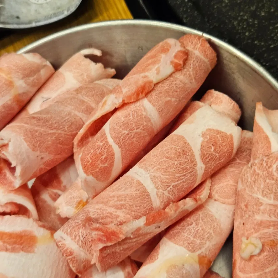 Sliced pork and accompaniments on the grill