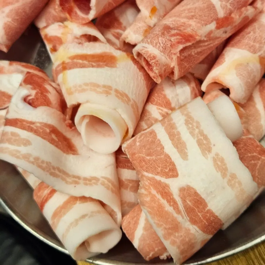 Tabletop grill with sliced pork cooking