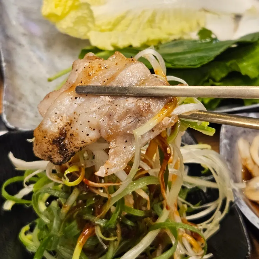 Piece of sliced pork placed on a wrap vegetable