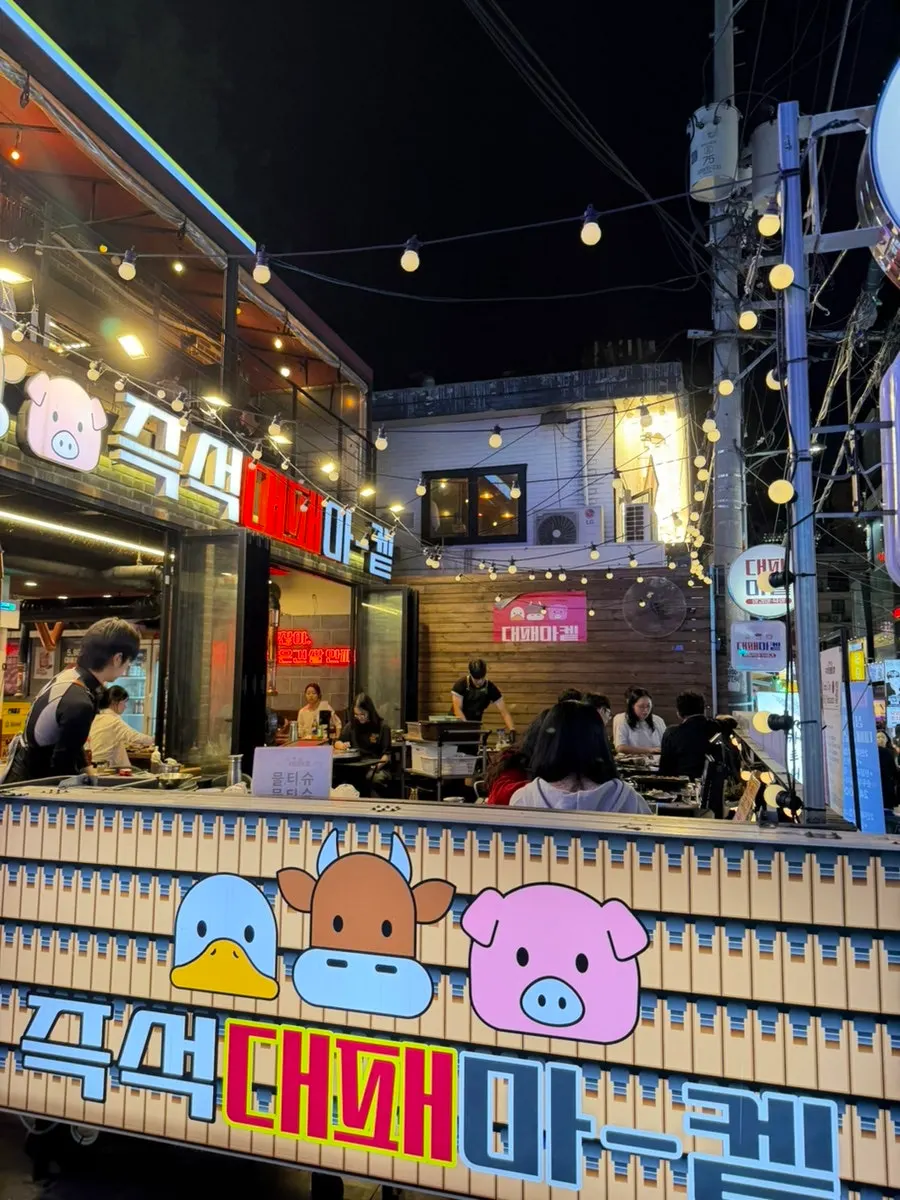 Evening view of outdoor seating at a Nonhyeon pork belly restaurant