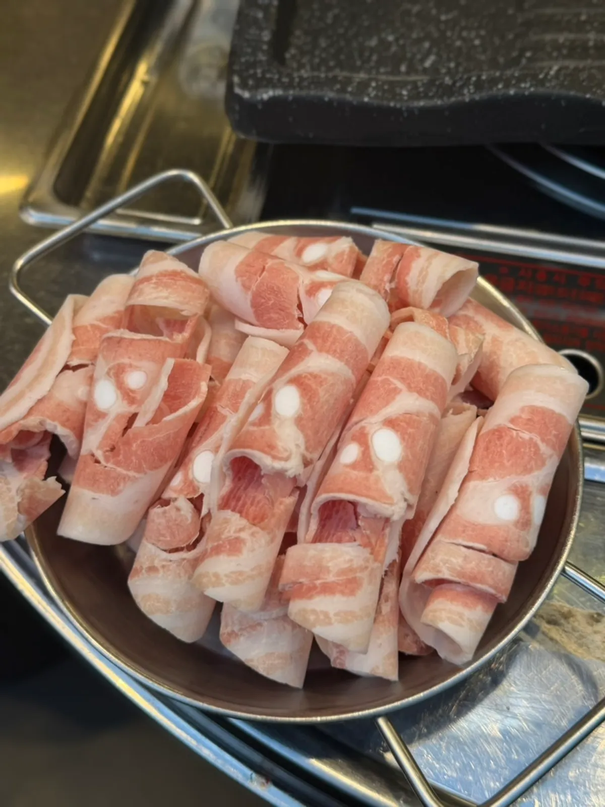 A table setting with 3 servings of thin-sliced pork belly