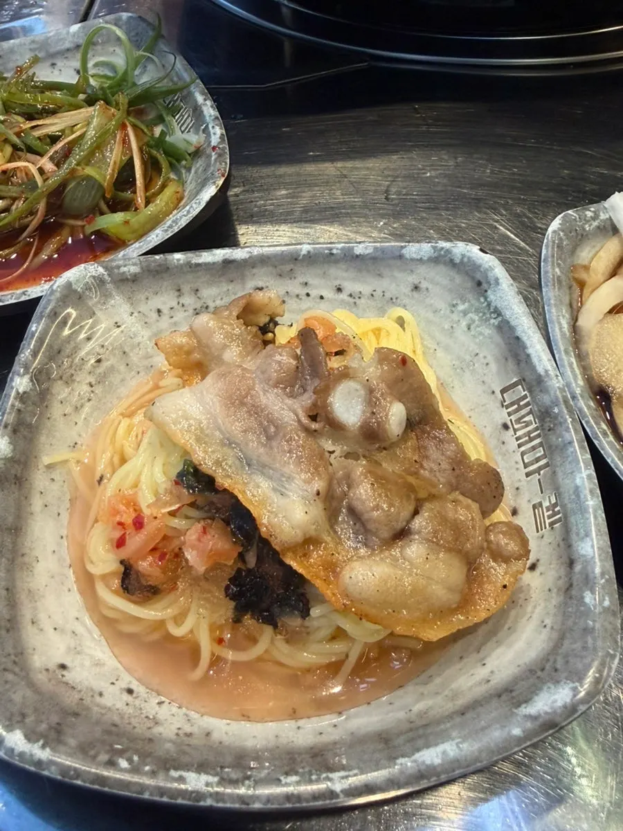 Thin-sliced pork belly rolled into kimchi noodle soup noodles
