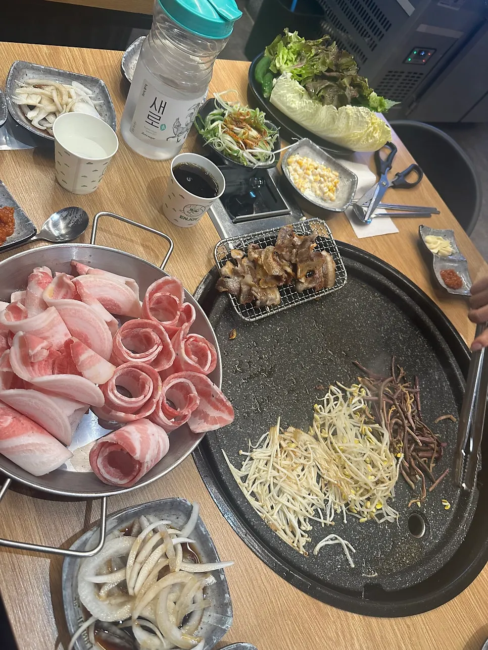 A spread of thin-sliced pork belly with wrap vegetables and side dishes