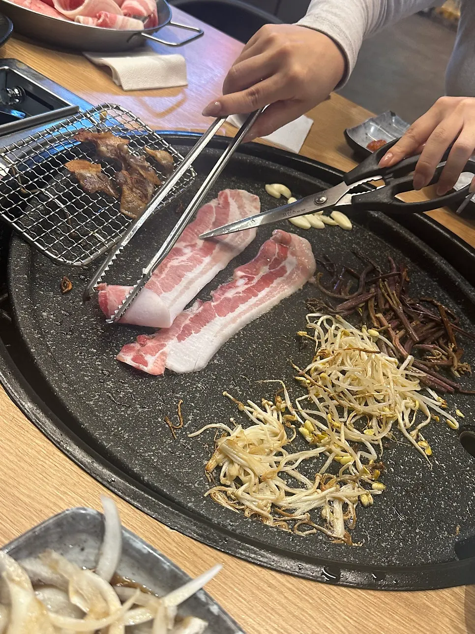 Freshly grilled thin-sliced pork belly picked straight off the pan