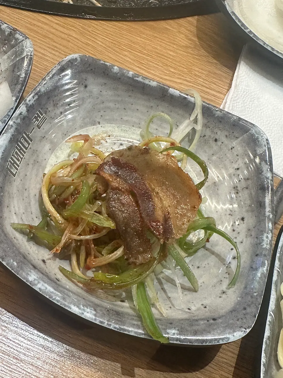 Thin-sliced pork belly placed on a lettuce wrap