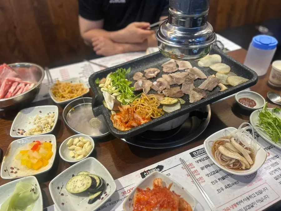 A plate loaded with salad bar vegetables and side dishes