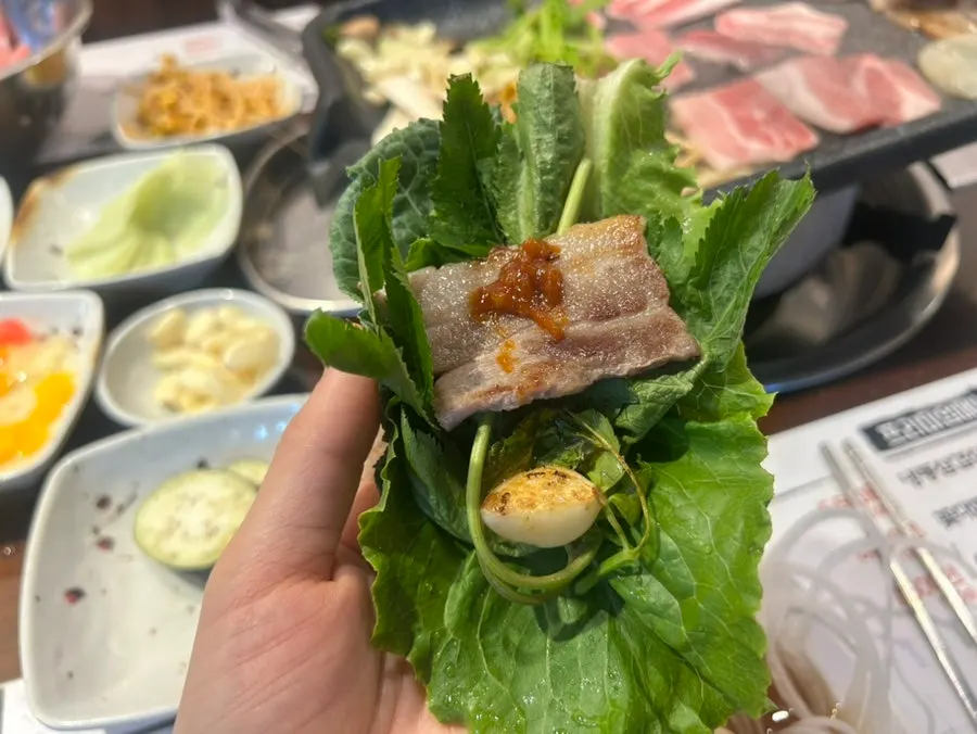 A bite of pork belly wrapped in lettuce