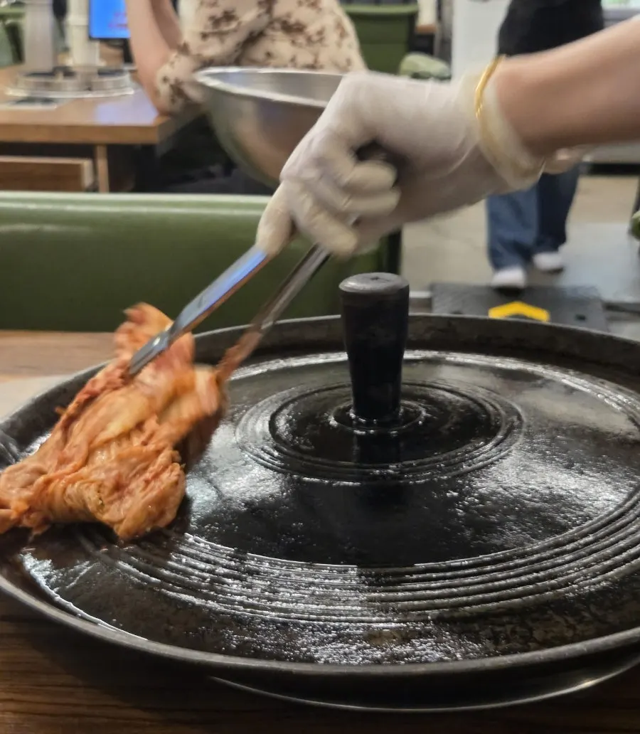 솥뚜껑에 올린 김치와 콩나물무침