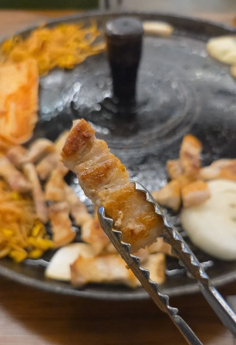 매콤한 소스에 찍은 삼겹살 한 점