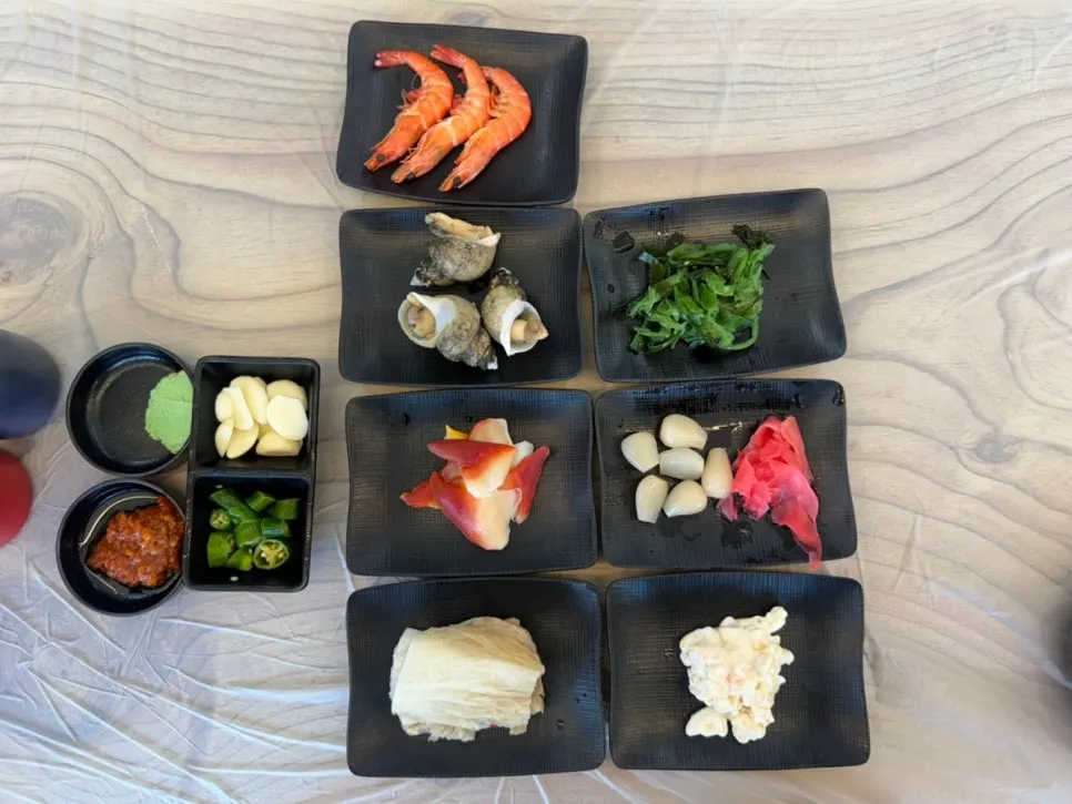 Table of banchan set out after ordering small flounder sashimi