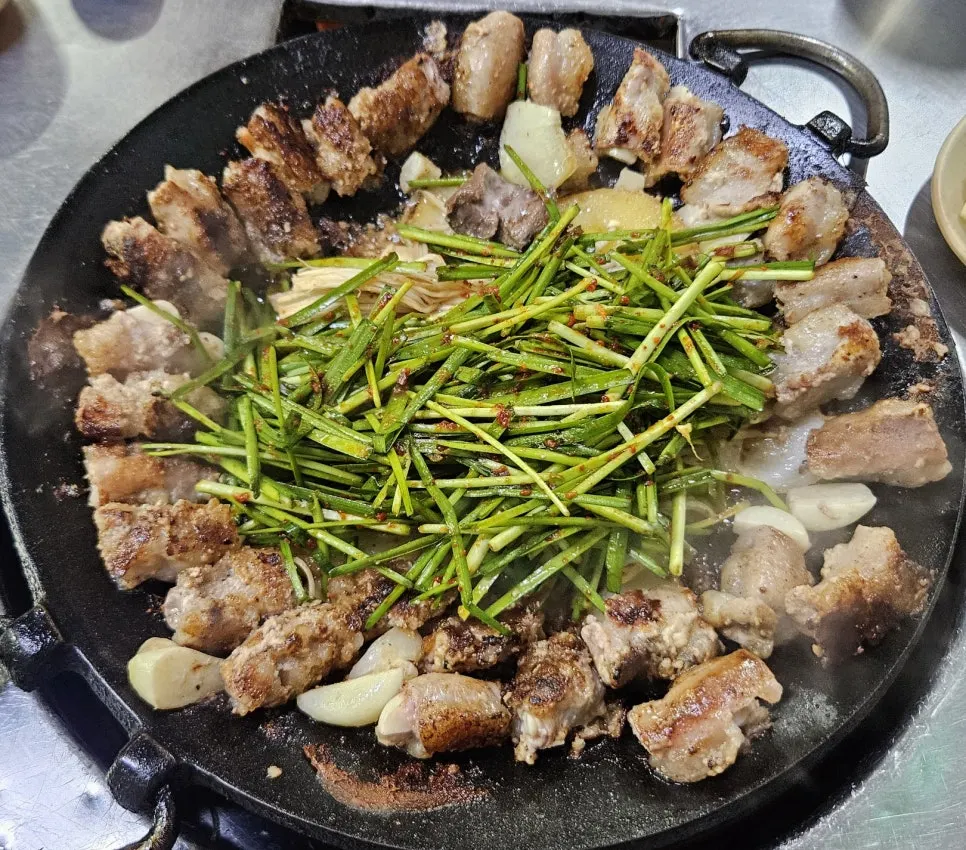 부추무침과 채소가 함께 깔린 마늘곱창 2인분 철판