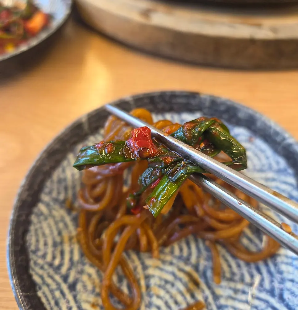 돌짜장 면 위에 파김치를 올린 모습