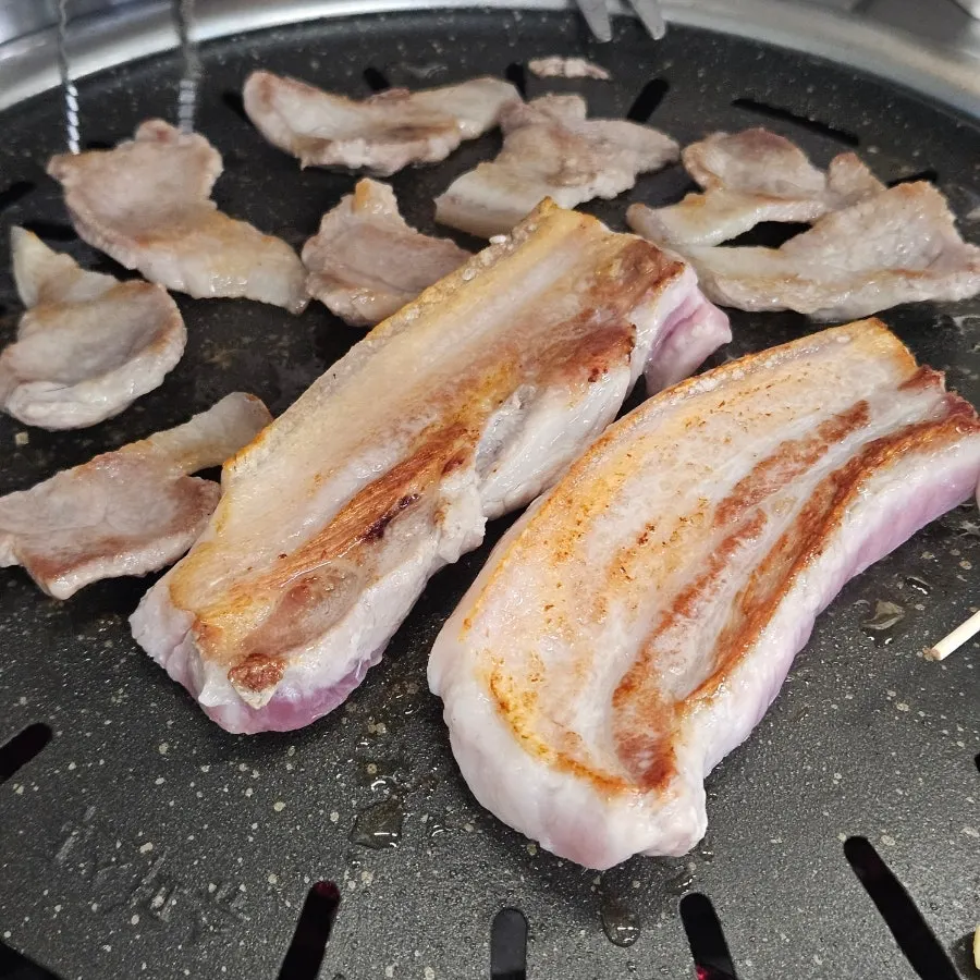 Pork belly and pork neck cooking over charcoal