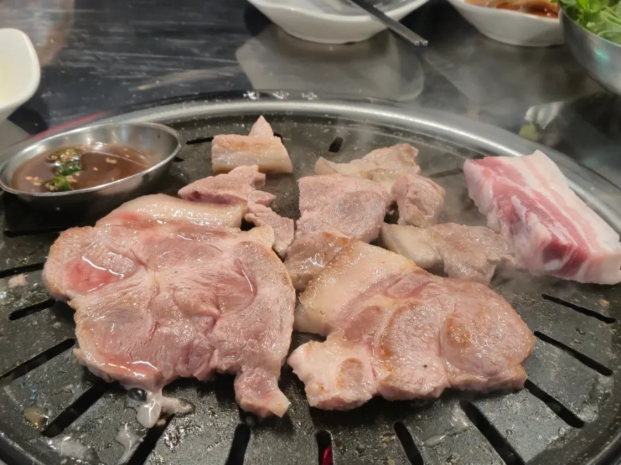 Jirye black pork platter cooking over charcoal