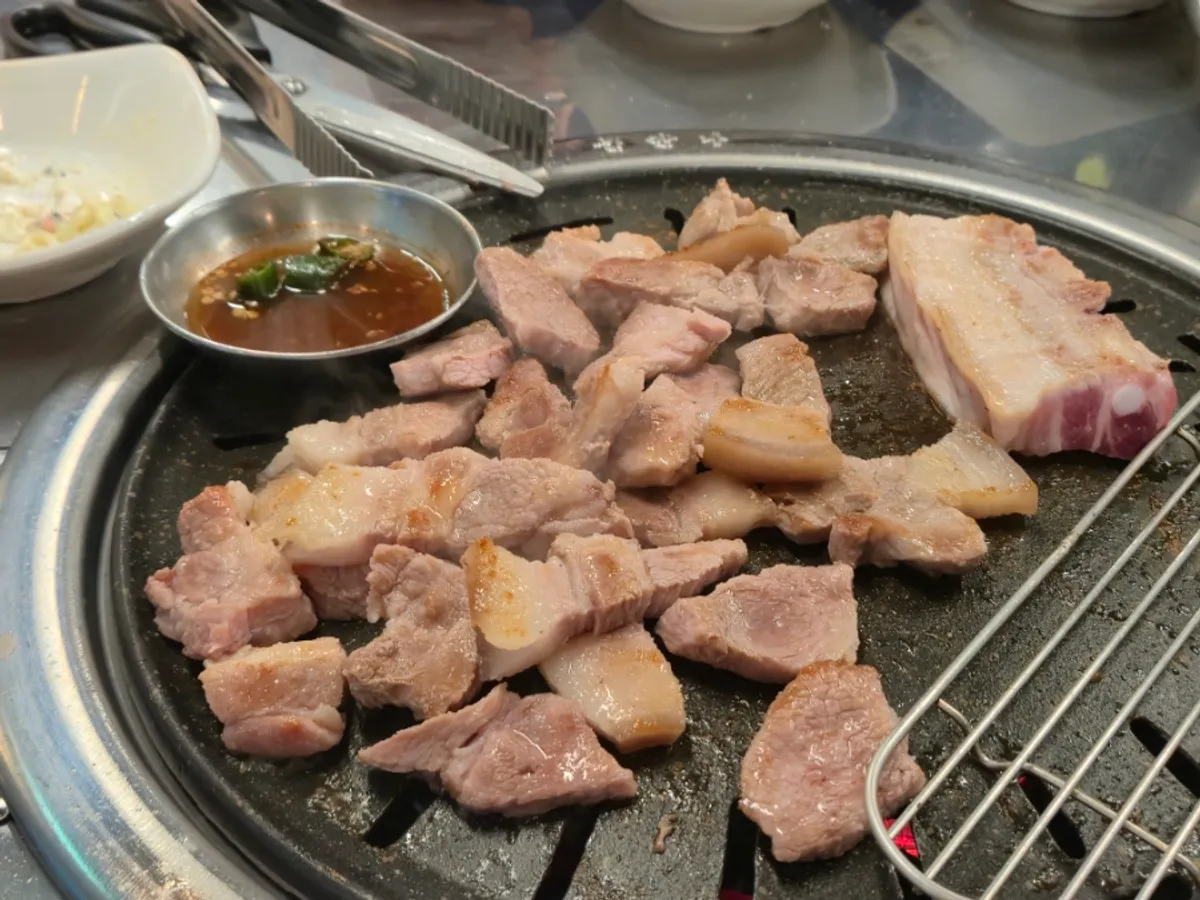 Thick-cut black pork grilling over charcoal