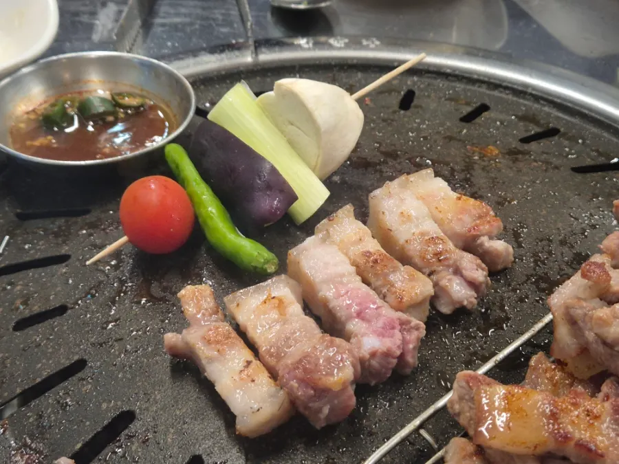 A piece of grilled black pork dipped in salt