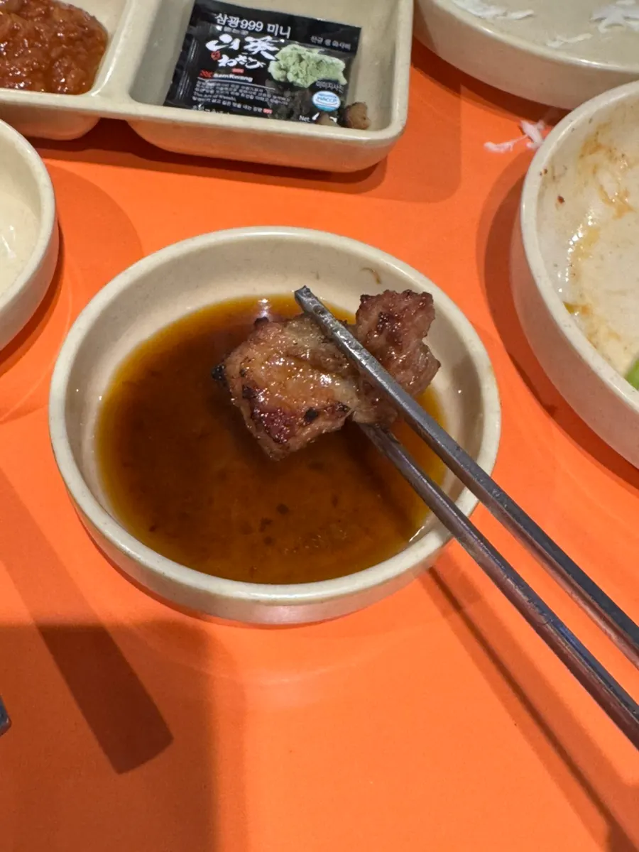 First bite of marinated ribs dipped in sauce